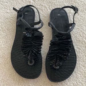 BCBGMaxAzria black leather sandal with floral appliqué